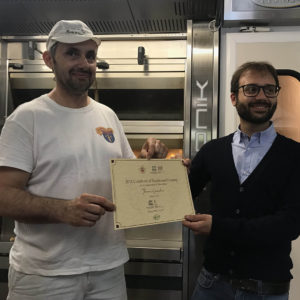 delivery of certificate of merit with local baker in Bologna